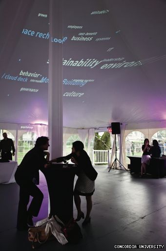 Delegates at the President’s Reception on the Grey Nun’s grounds catch up under an Espace Recherche projection.